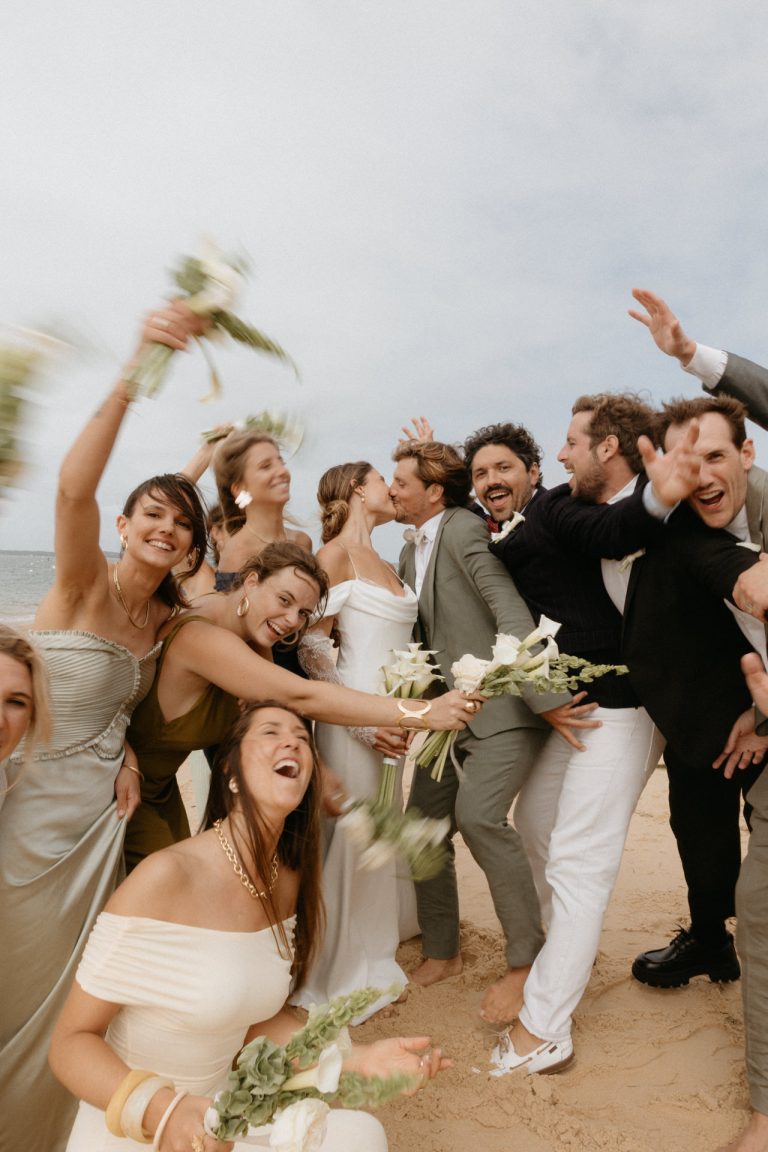 Les mariés sont au centre de tous leurs amis et famille : ils s'embrassent pendant que leurs proches font la fête et célèbrent leur union. Un moment fun capté par par Lesley Sanchez, photographe Landes.